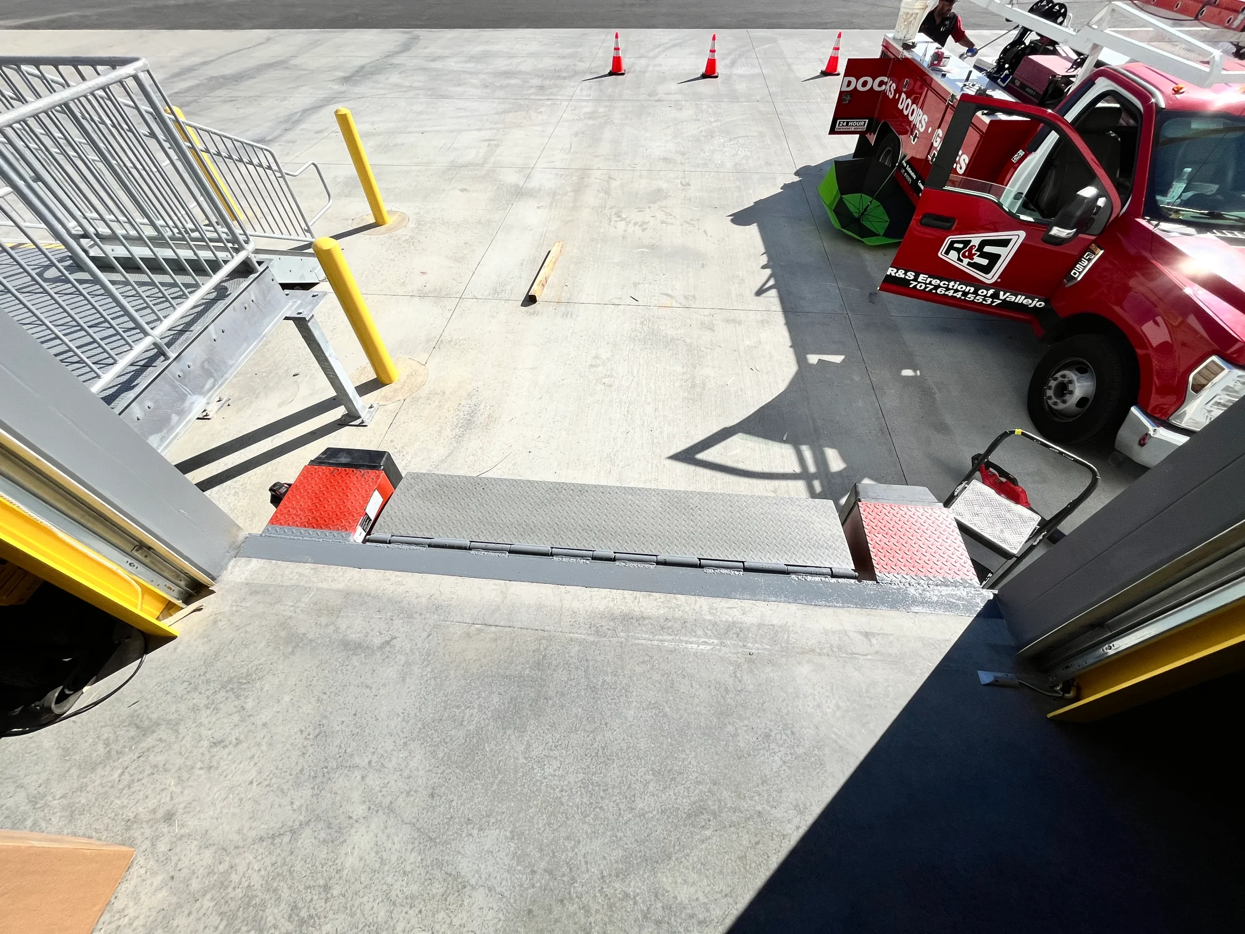 Top-down interior view of a commercial dock leveler lip extended toward the driveway, depicting common operational loading dock problems and maintenance needs.